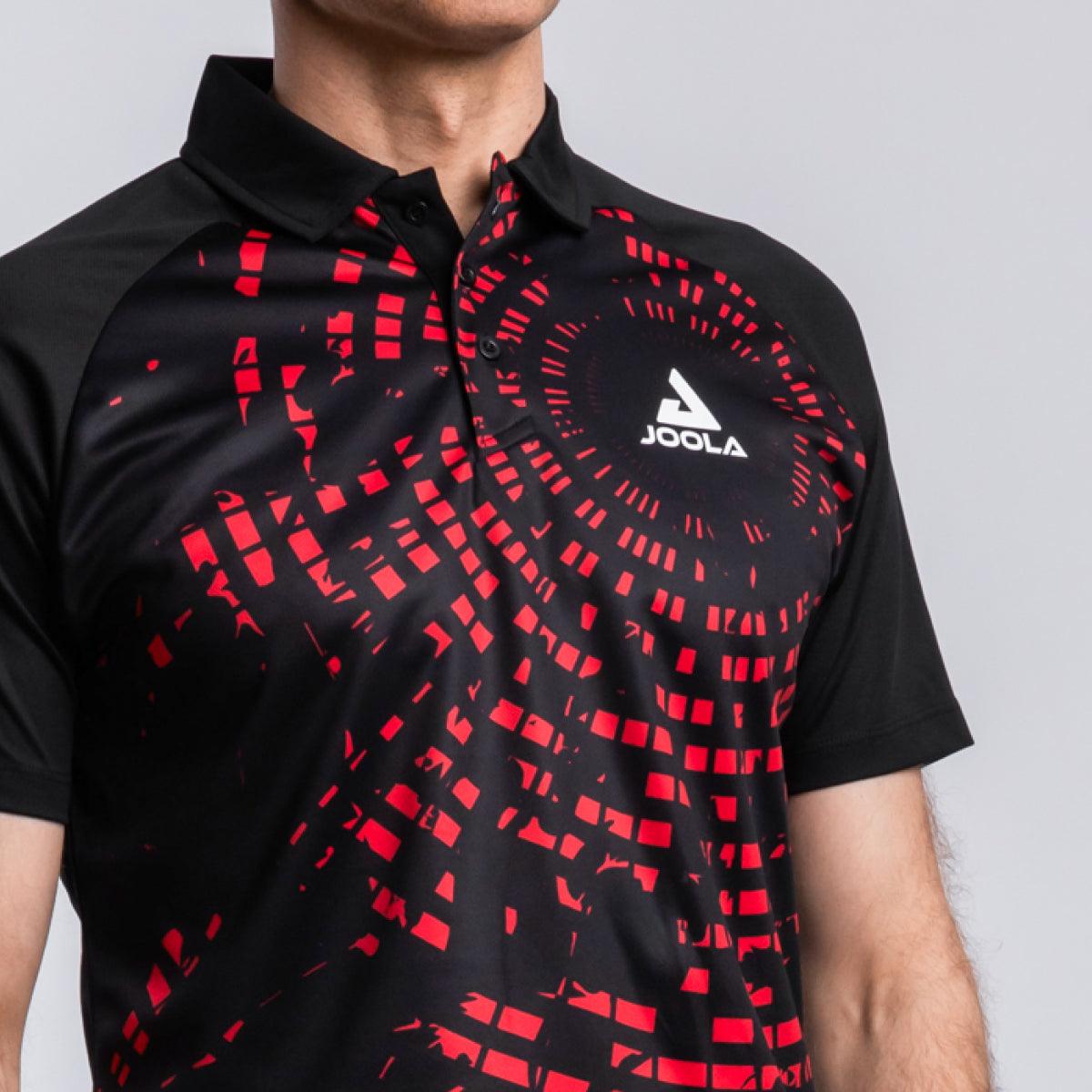 Schwarzes JOOLA Polo-Shirt mit rotem, pixelartigem Muster und kurzem Arm, getragen von einem Mann.