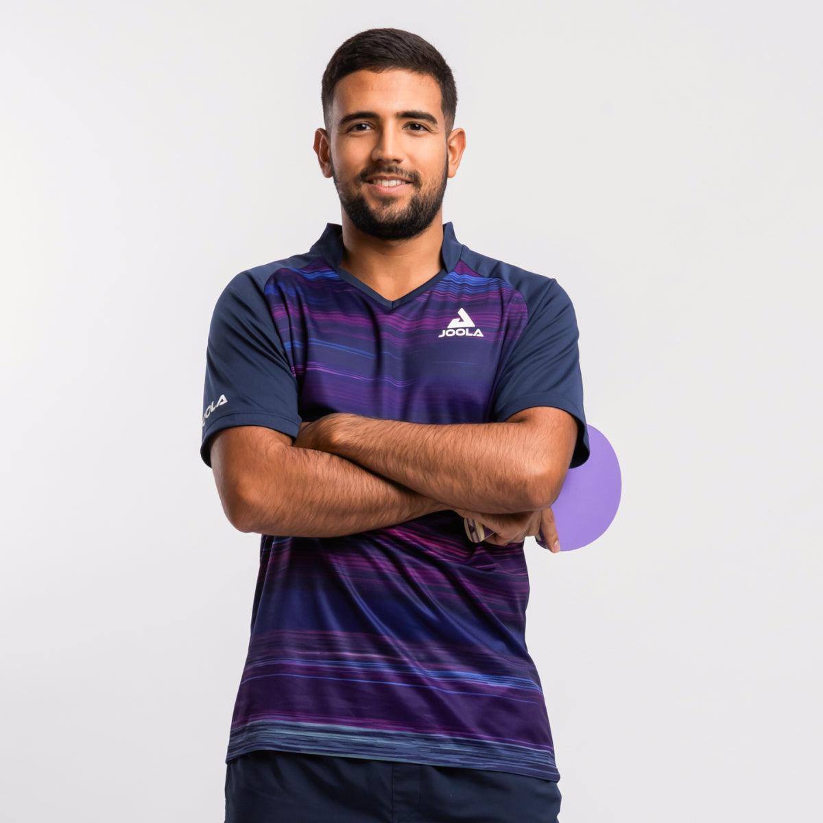 Mann trägt blau-lila gestreiftes JOOLA Tischtennis-Trikot und hält lila Tischtennisschläger.
