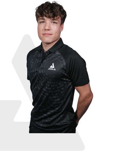 Junger Mann trägt schwarzes JOOLA Polo-Shirt mit dezentem Muster und Logo auf der Brust, weißer Hintergrund.