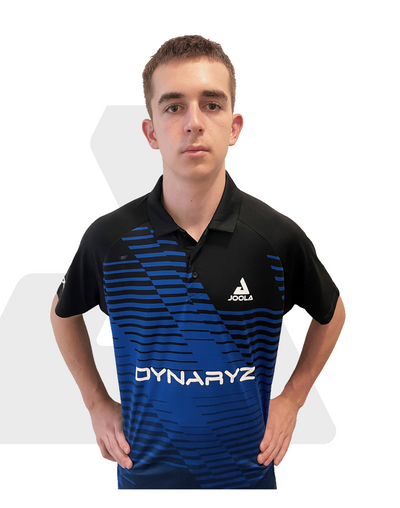 Junger Mann trägt blau-schwarzes JOOLA Polohemd mit Dynaryz-Logo, Hände in Hüftposition, neutraler Gesichtsausdruck.