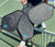 Vier schwarze JOOLA Pickleball-Schläger mit weißem Griff auf einem Tennisplatz über dem Netz gehalten.